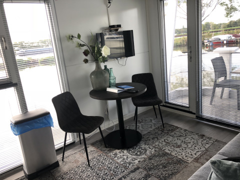 Kleine zithoek met twee stoelen en ronde tafel, decoratief met vaas en boeken, bij Marina Parcs Amsterdam.