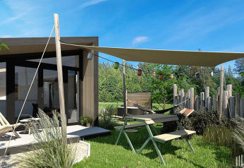 Area esterna della Tiny Wellness Cabin al Holiday Park De IJsvogel con tenda da sole e arredi da giardino, Paesi Bassi.