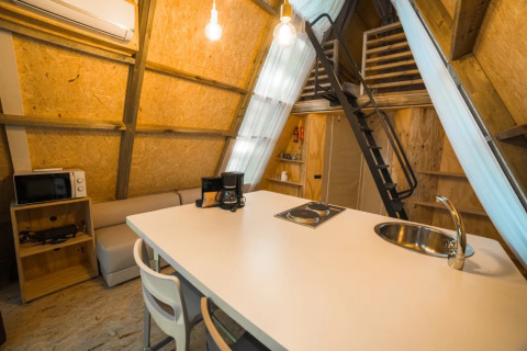 Interieur van safaritent 'A Luxury' bij Trasimeno Glamping Resort, met keuken en slaapzolder.