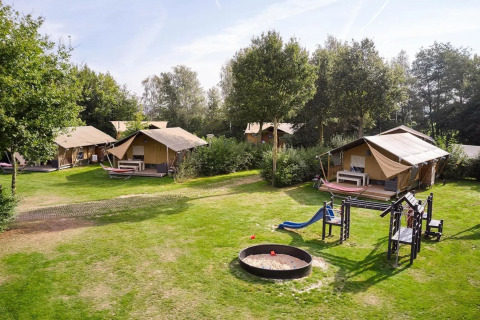 Tentes safari et aire de jeux sur gazon au Papillon Country Resort aux Pays-Bas, journée ensoleillée.