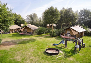 Safari telte og legeplads i grønne omgivelser på Papillon Country Resort i Holland, solrig dag.