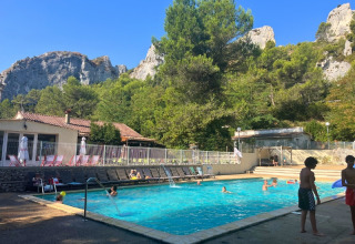 Schwimmbad am Campingplatz La Vallée Heureuse vor Bergen und Wald in Provence-Alpes-Côte d’Azur, Frankreich.