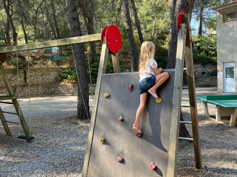 A child climbs on the playground climbing wall at Campsite La Vallée Heureuse in Provence-Alpes-Côte d’Azur, France.