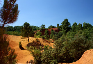 Paesaggio con scogliere rosse e pini al campeggio La Vallée Heureuse in Provenza-Alpi-Costa Azzurra, Francia.