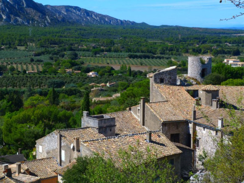 View of rooftops, stone buildings, and lush countryside near Orgon, Provence-Alpes-Côte d’Azur, France.