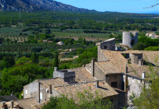 View of rooftops, stone buildings, and lush countryside near Orgon, Provence-Alpes-Côte d’Azur, France.