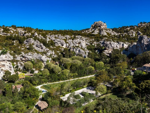 Rocky hills and lush greenery near Orgon in Provence-Alpes-Côte d’Azur, France, beneath a clear blue sky.