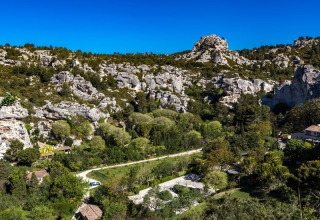 Colline rocciose e vegetazione rigogliosa vicino a Orgon, Provenza-Alpi-Costa Azzurra, Francia, sotto cielo azzurro.