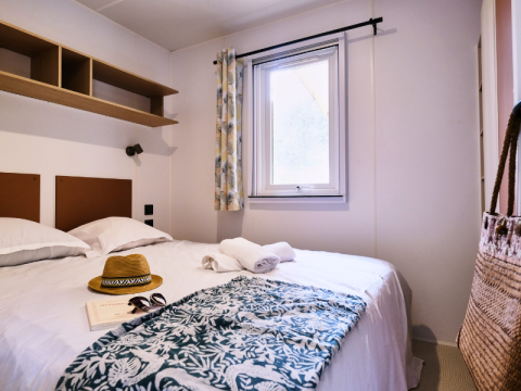 Dormitorio en Mobile Home Premium en el camping La Vallée Heureuse en Francia con cama doble.