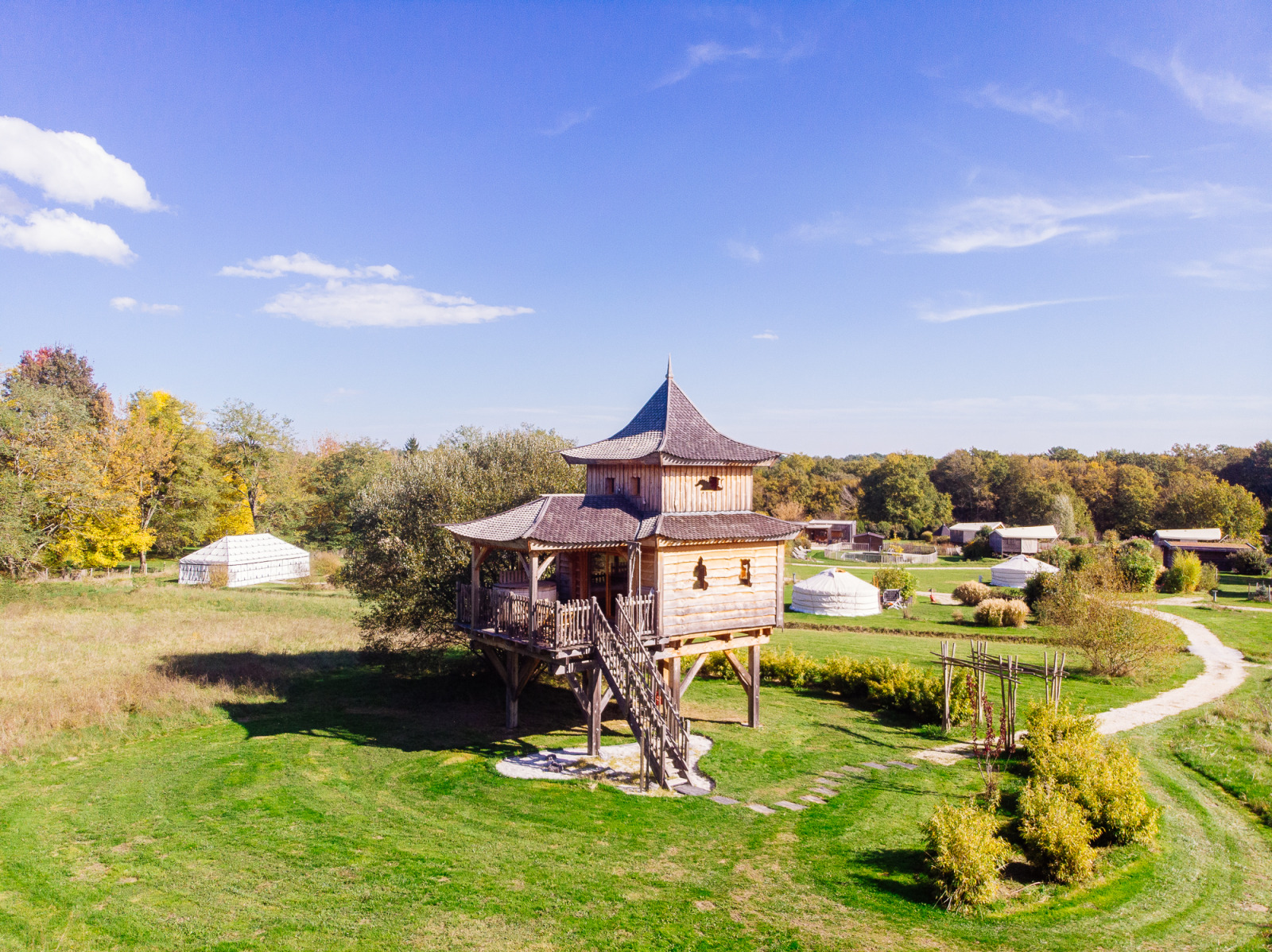 Boomhut Log cabin «Temple perché» bij Domaine EcÔtelia in Frankrijk, omgeven door natuur en blauwe lucht.