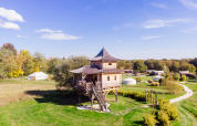 Cabane dans les arbres «Temple perché» au Domaine EcÔtelia, France, entourée de verdure et de ciel bleu.