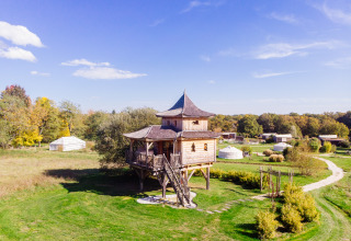 Casa del árbol llamada Log cabin «Temple perché» en Domaine EcÔtelia, Francia, rodeada de naturaleza.