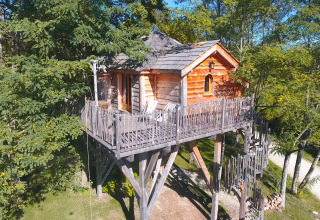 Baumhaus auf Stelzen im Ferienpark Domaine EcÔtelia, Nouvelle-Aquitaine, Frankreich, tagsüber.