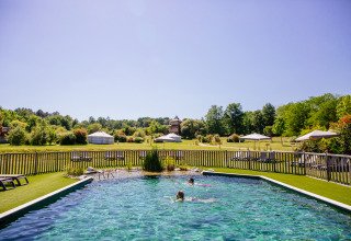 Natuurlijke zwembad met mensen aan het zwemmen in Domaine EcÔtelia, vakantiepark in Nouvelle-Aquitaine, Frankrijk.