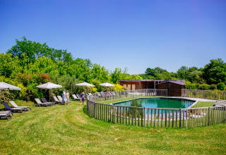 Natürlicher Pool mit Liegen und Sonnenschirmen im Grünen bei Domaine EcÔtelia, Nouvelle-Aquitaine, Frankreich.