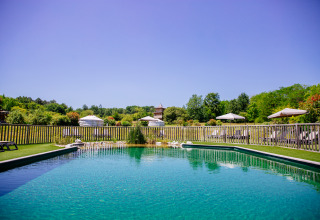 Natuurlijk zwembad met ligzetels bij Domaine EcÔtelia vakantiepark in Nouvelle-Aquitaine, Frankrijk.