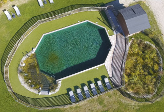 Vue aérienne d'une piscine octogonale avec transats et espaces verts au Domaine EcÔtelia, Nouvelle-Aquitaine, France.