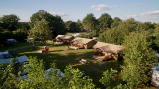 Luftaufnahme des Safari-Zelts Appelgaard auf einem grünen Campingplatz mit Bäumen und klarer Himmel.