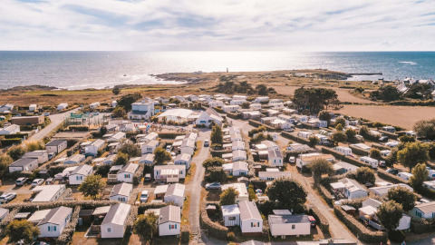 Vista aerea di Flower Camping La Pointe du Talud con bungalow vicino alla costa in Bretagna, Francia.