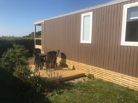 Terrasse extérieure avec chaises au Mobile home «Premium LIVING» au Flower Camping La Pointe du Talud, France.