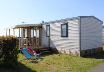 Outdoor view of the Mobile home Premium HORIZON featuring a covered deck and lawn chairs in sunshine.