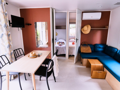 Bright, modern interior of Mobile Home Premium at Campsite La Vallée Heureuse, France, with cozy furnishings.