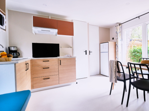 Bright, modern kitchen and living area inside the Mobile Home Premium at Campsite La Vallée Heureuse, France.