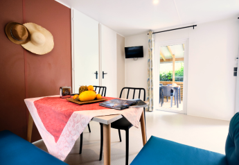 Eethoek in de mobilhome 'Premium Large' op camping La Vallée Heureuse, Frankrijk, met fruit op tafel.