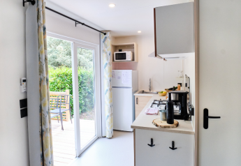 Modernes Mobilheim-Küche mit Schiebetüren zur Terrasse und Garten im Camping La Vallée Heureuse.