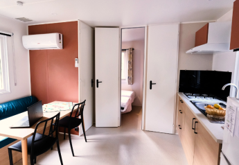 Interieur van Mobile Home Premium op Camping La Vallée Heureuse in Frankrijk, met keuken en eetruimte