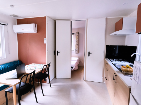 Intérieur du Mobile Home Premium au Camping La Vallée Heureuse en France, avec cuisine et salle à manger