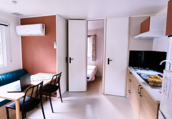 Innenraum des Mobile Home Premium auf dem Campingplatz La Vallée Heureuse in Frankreich mit Küche und Essbereich