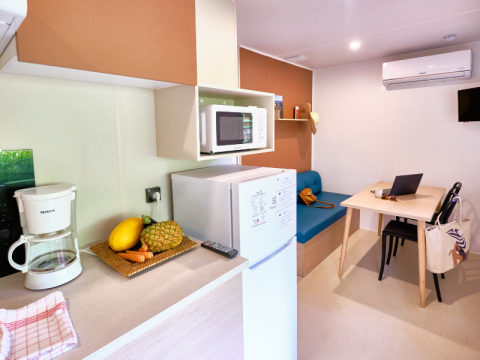 Kitchenette and dining area inside a Premium Mobile Home at Campsite La Vallée Heureuse, France.