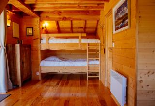 Treehouse room at Log cabin Temple perché, Domaine EcÔtelia, France, featuring bunk beds and wooden decor.