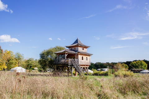 Baumhaus Log cabin «Temple perché» im Domaine EcÔtelia, Frankreich, umgeben von Natur und Zelten.