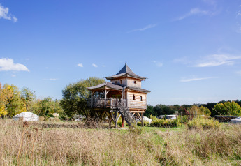 Baumhaus Log cabin «Temple perché» im Domaine EcÔtelia, Frankreich, umgeben von Natur und Zelten.
