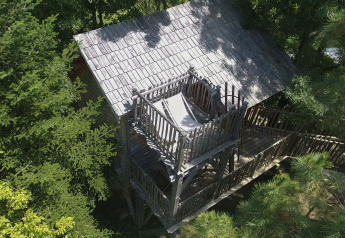 Luftaufnahme des Baumhauses Palombière im Domaine EcÔtelia, Frankreich, umgeben von grünen Bäumen.