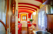 Colorful and cozy interior of the Gypsy wagon cabin at Domaine EcÔtelia in France, featuring wooden panels.