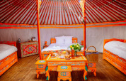 Intérieur d'une yourte colorée au Yurt at Domaine EcÔtelia en France, avec meubles peints et ambiance chaleureuse.