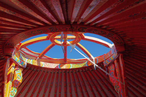 Vista de la abertura decorada del techo de una yurta en Domaine EcÔtelia, Francia, bajo el cielo azul.