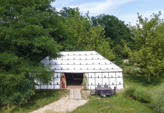 Safari-teltet Tent «Caïdale» på Domaine EcÔtelia i Frankrig, omgivet af frodige træer og natur.