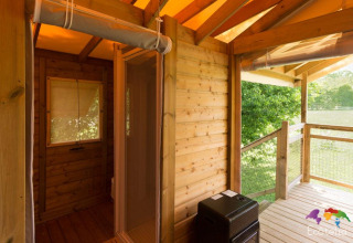 Vista dalla terrazza della tenda Safari al Domaine EcÔtelia in Francia, con pareti in legno e natura verde.