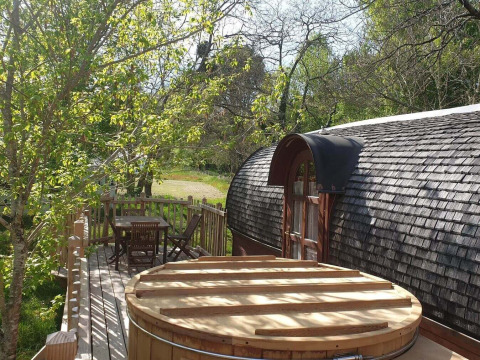 Knus houten terras met buitenbad aan de Caravan-hut bij Domaine EcÔtelia in Frankrijk.