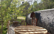Acogedora terraza de madera con bañera exterior en la cabaña Caravan en Domaine EcÔtelia, Francia.