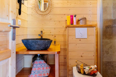Salle de bain d'une cabane indonésienne au Domaine EcÔtelia, France, murs en bois et décor moderne.