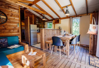 Innenansicht der Océania Lodge bei Domaine EcÔtelia in Frankreich mit Holzdekor und gemütlichem Essbereich.