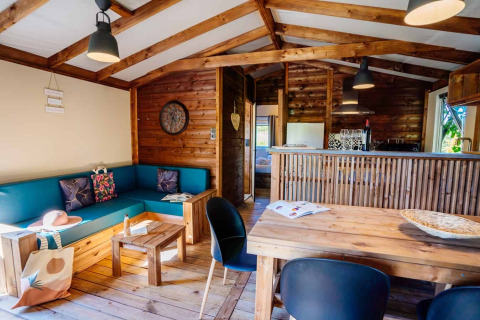 Innenaufnahme der Océania Lodge im Domaine EcÔtelia, Frankreich, mit Holzdekor und gemütlichem Wohnraum.