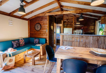 Interior view of Océania Lodge at Domaine EcÔtelia in France, featuring wooden decor and a cozy living area.