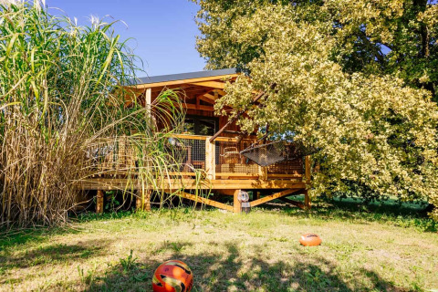Das Océania Lodge im Domaine EcÔtelia, Frankreich, eine gemütliche Holzhütte umgeben von Natur und grüner Wiese.