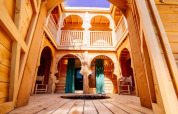 Interior de madera de la cabaña Riad con arcos y balcones en Domaine EcÔtelia, Francia.